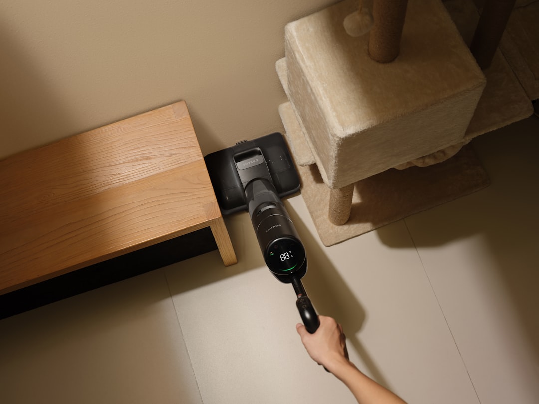A Dreame wet dry vacuum cleans along the edge near a cat tree, presenting a floor cleaner solution for pet homes.